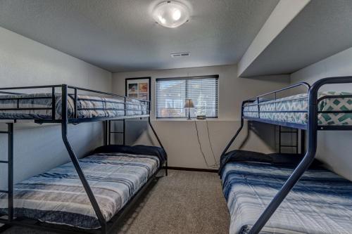 two bunk beds in a room with a window at Executive Golf Club Red Rocks Home, Locally Owned! in Rapid City