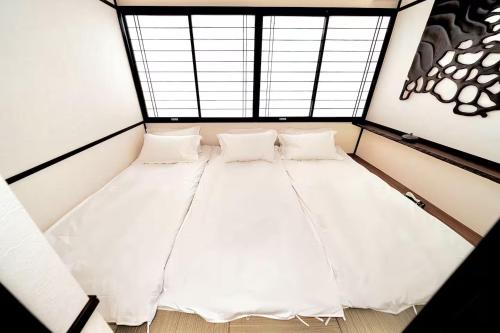 una cama en una habitación con ventana en 北川秋叶原 羽田机场直达 秋叶原站步行4分钟的和风民宿 卫生间偏小 适合家庭和情侣入住, en Tokio