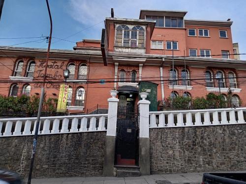 un edificio de ladrillo con una valla blanca delante de él en Hostal Tambo de Oro, en La Paz