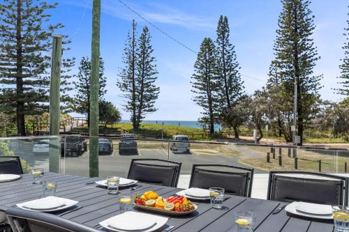 une table avec un bol de fruits sur un balcon dans l'établissement Beachfront with pool ocean views and pet friendly, à Buddina