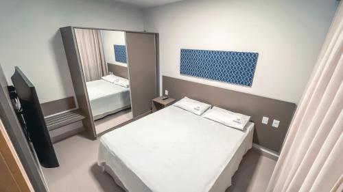 a small room with a bed and a mirror at Equilíbrio PARK VEREDAS - Rio Quente-Goias in Rio Quente