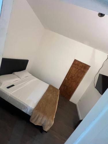 ein Schlafzimmer mit einem Bett und einem Holztisch in der Unterkunft Hostel Bauti ezeiza in Ezeiza