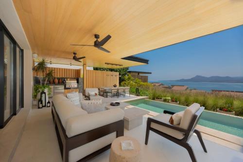 a patio with a couch and chairs and a pool at 4 Bed - Luxury Oceanview Villa in Punta Mita