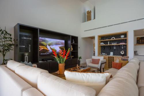 a living room with a white couch and a tv at 4 Bed - Luxury Oceanview Villa in Punta Mita
