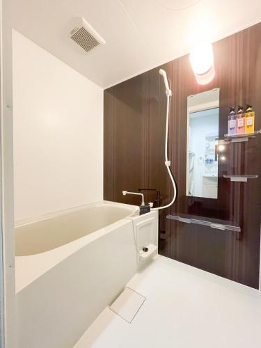 a bathroom with a bath tub and a sink at Villa Awase 111 in Okinawa City