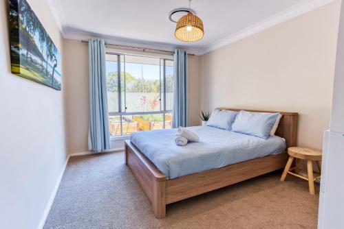 ein Schlafzimmer mit einem Bett und einem Fenster in der Unterkunft 523 by the Sea in Broadwater