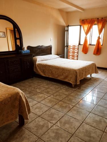 a bedroom with two beds and a mirror at Hotel Dulce Morelia in Morelia