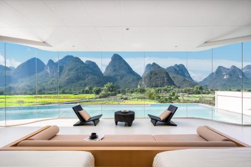 a living room with a view of mountains at Paddy Fields Resort-Guilin Shuidaotian in Yangshuo