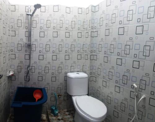 a bathroom with a toilet and a shower at Wisma Raudah Wakatobi in Mandati