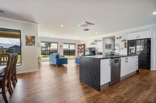 an open kitchen and living room with a table and chairs at Alpine Corner - Lux and Quiet in Thurgoona