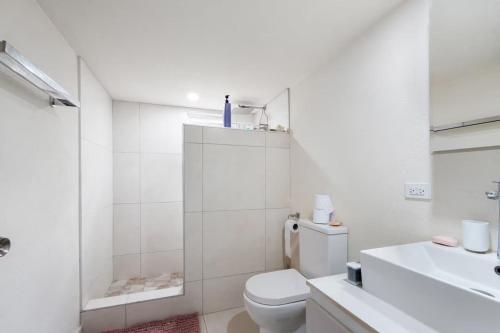 ein weißes Badezimmer mit Toilette und Waschbecken in der Unterkunft 2 Bedroom - 1 Bath Condo - 2 min walk to beach in Bridgetown