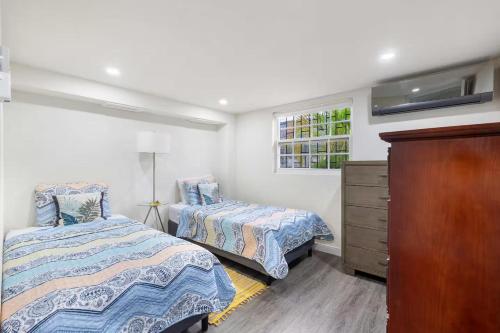 ein Schlafzimmer mit zwei Betten und einer Kommode in der Unterkunft 2 Bedroom - 1 Bath Condo - 2 min walk to beach in Bridgetown