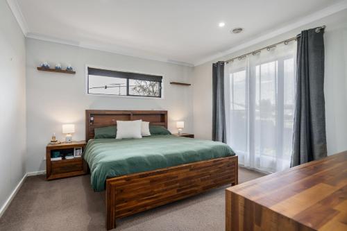 una camera da letto con un letto e una grande finestra di Alpine Corner - Lux and Quiet a Thurgoona