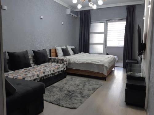 Center-Train Station-Airport في Toshkent-Passajir Bekati: غرفة نوم بها سرير وأريكة