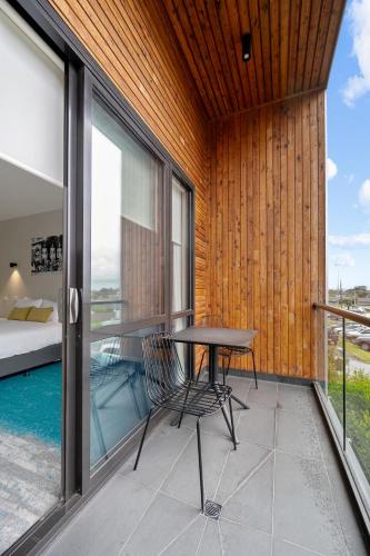 a table and a chair on a balcony with a bed at MJ McMahon Motel in Wonthaggi