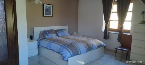 a bedroom with a bed with blue sheets and a window at Casa Pinocchio in Viù