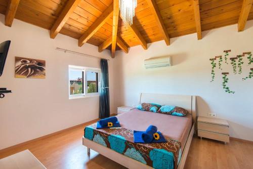 ein Schlafzimmer mit einem Bett mit zwei Stofftieren darauf in der Unterkunft Haus In Kolympia Mit Parkplatz Und Bergblick in Kolymbia