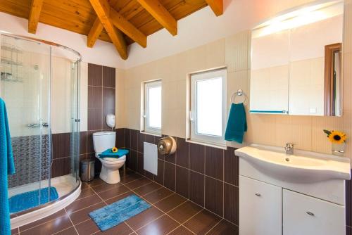 ein Badezimmer mit Toilette, Dusche und Waschbecken in der Unterkunft Haus In Kolympia Mit Parkplatz Und Bergblick in Kolymbia