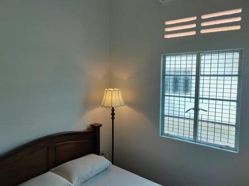 Un dormitorio con una cama y una lámpara y una ventana. en Zen 1 Room KL, en Kuala Lumpur