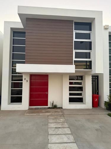a red door on a building with a red garage at New House Near The Beach in Ensenada