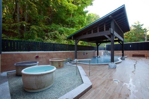 a pavilion with a fountain in a park at Yumoto Koganeyu in Jozankei