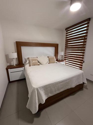 a bedroom with a large bed with white sheets and pillows at New House Near The Beach in Ensenada