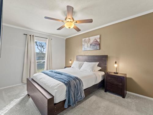 une chambre avec un lit avec un ventilateur de plafond dans l'établissement Red Door Hideaway 3bd, Hot Tub, Foosball, à The Colony