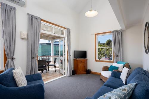 a living room with a blue couch and a tv at City Apartment South Street in Nelson