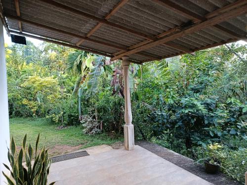 eine Holzveranda mit Pergola in einem Garten in der Unterkunft Relax home in Kegalle