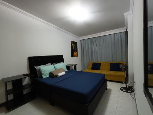 Estación El SaltoCasa Familar en Pereira, Cerca a Expofuturo, Estadio, Villa Olímpica的一间卧室配有蓝色的床和黄色的沙发