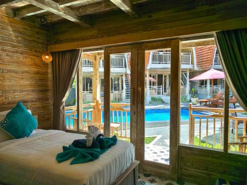 a bedroom with a bed and a view of a pool at Brady's Ubud Villas in Ubud