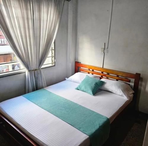 a bedroom with a large bed with a window at Hotel Americano Plus in Pereira