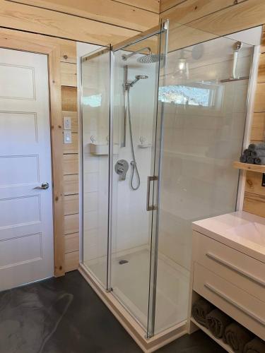 a shower with a glass door in a bathroom at Chalet L'Orée Étoilée in La Tuque