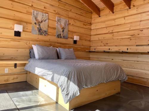 een slaapkamer met een bed in een blokhut bij Chalet L'Orée Étoilée in La Tuque