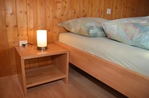 a bedroom with a bed with a candle on a night stand at Ferienwohnung Sutter In Brülisau Bei Appenzell in Rüthi