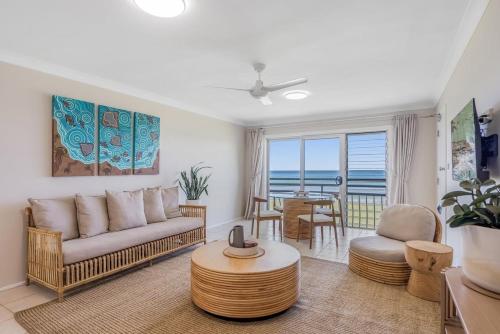 a living room with a couch and a table at Absolute Beachfront Apartment 2T in Lennox Head