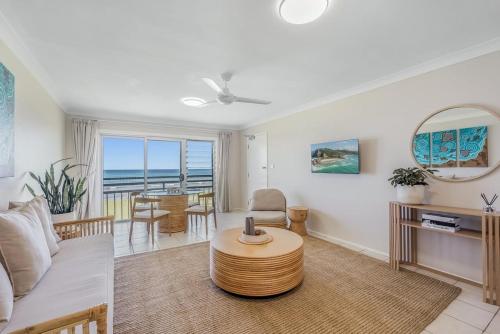 a living room with a couch and a table at Absolute Beachfront Apartment 2T in Lennox Head