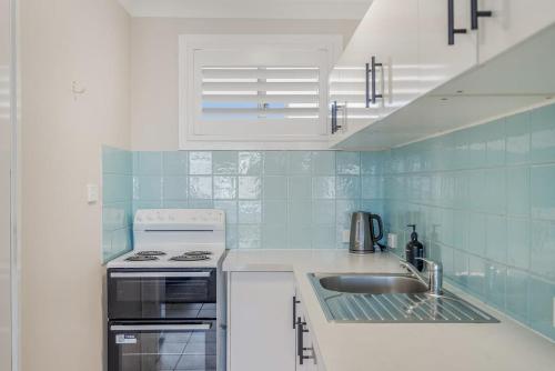 a kitchen with a sink and a stove at Absolute Beachfront Apartment 2T in Lennox Head