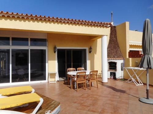 a patio with a table and chairs and a fireplace at Großes Modernes Ferienapartment Villa Atlantico in La Pared