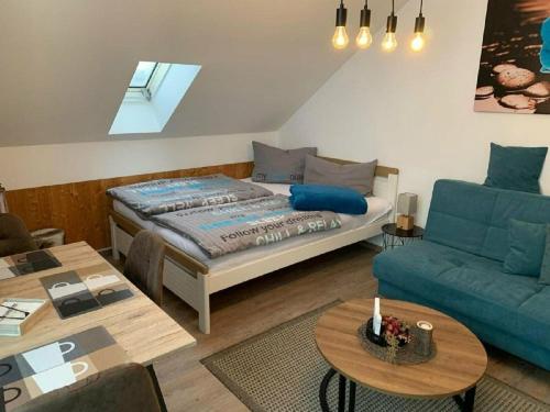 a bedroom with a bed and a couch and a table at Charmante Wohnung In Langfurth Mit Kleinem Balkon in Schöfweg