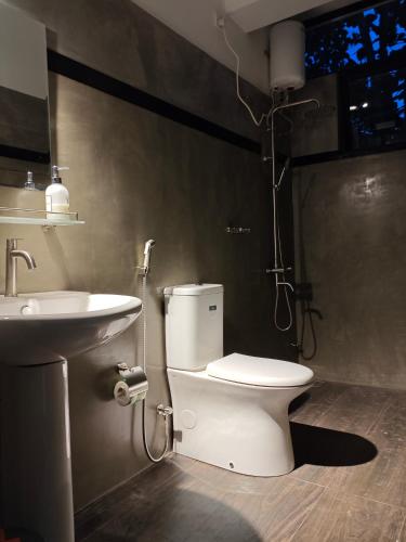 a bathroom with a toilet and a sink at Lagoonai Villa in Sinimodera