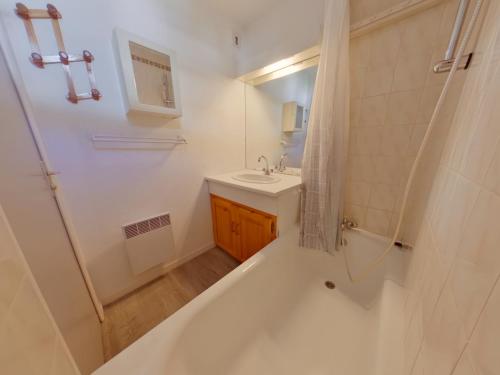 ein Badezimmer mit Badewanne, Waschbecken und Dusche in der Unterkunft Appartement cosy aux Rousses avec terrasse et proximité activités - FR-1-834-8 in Les Rousses