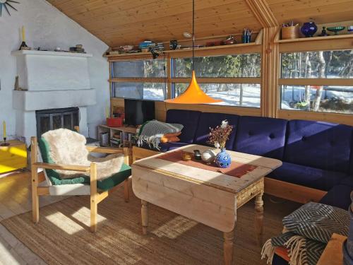 a living room with a blue couch and a table at Ål Cabin With Panoramic Views in Favang