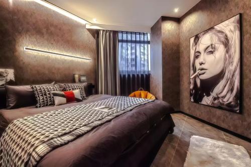 a bedroom with a bed and a painting on the wall at Shanghai Hills&Rais Apartment - 100-inch Projector - Near Nanjing Road Pedestrian Street in Shanghai