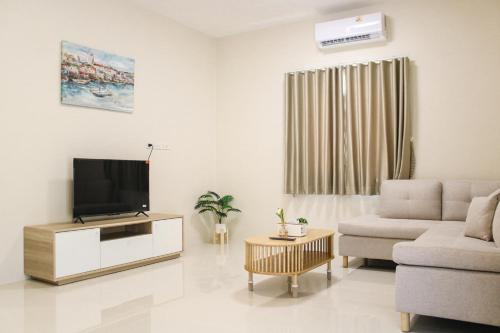 a living room with a television and a couch at Garden Villa Khaolak in Khao Lak