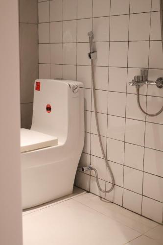 a white toilet in a bathroom with a shower at GIA Hotel & Serviced Apartment in Nhơn Trạch