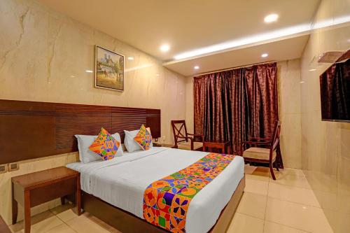 una habitación de hotel con una cama y una silla en Hotel Continental Inn, en Chennai