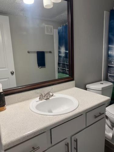 a bathroom with a sink and a mirror at Sports Fan Getaway less than 2mi to AT&T Stadium Pool and Gym! in Arlington