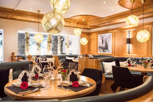 a dining room with tables and chairs and chandeliers at Verwöhnhotel Wildspitze in Sankt Leonhard im Pitztal