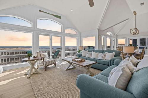 ein Wohnzimmer mit blauen Sofas und Fenstern in der Unterkunft Blue Moon - LUX Oceanfront Pool Hot Tub Theater in Waves